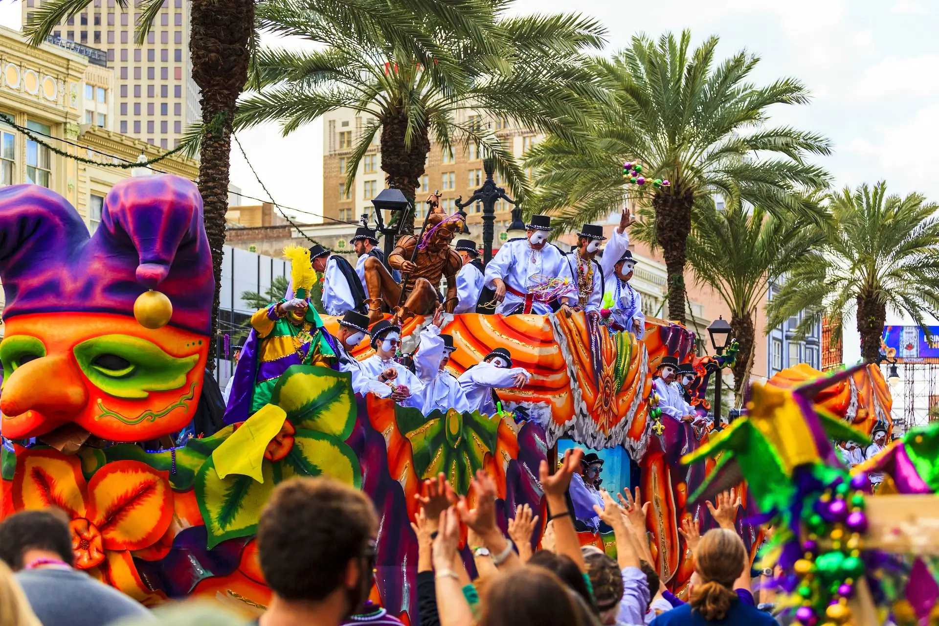 Staying Safe This Mardi Gras Season - and What to Do If You’re Injured on the Parade Route. An image of a Mardi Gras float passing by parade-goers at Mardi Gras in New Orleans, Louisiana.