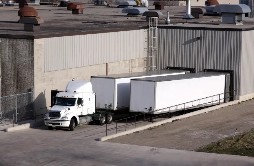 Trucks backed into loading facility for cargo with focus on curb weight vs GVWR safety